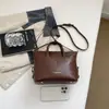 2026 Nuevo Bolso Almohada Boston Estilo Maillard para Mujer Bolso de Mano Retro Bolso de Hombro Cruzado Decoración de Bola de Pelo para Viajes Diarios
