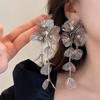 Nuevos pendientes de flores doradas de estilo chino, ligeros, de lujo, de alta gama, estilo retro nacional, pendientes largos exagerados, colgantes con borlas de nicho.