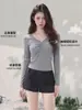 Elegante camiseta de color liso con cuello en V para mujer, colección de otoño, con corte entallado, detalles de botones, mangas largas únicas y un efecto adelgazante, perfecta como capa base clásica