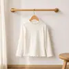 Nueva camisa base de otoño estilo coreano dulce versátil de punto con tacto de algodón con volantes de cuello medio alto de manga larga para niñas
