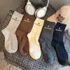 Nuevos estilos de otoño e invierno: calcetines para mujer con letras estampadas, de longitud media hasta la pantorrilla, modernos en colores sólidos negro, blanco y gris, atléticos, cómodos y versátiles