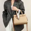Lenço Grátis com Bolsa Kelly Platinum Transfronteiriça, Nova Bolsa Elegante Ladylike com Fecho de Comércio Exterior, Bolsa de Ombro e Mão da Moda para Mulheres