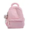Mochila rosa sencilla para estudiantes mujeres, mochila estilo japonés ins de gran capacidad con lindo colgante de peluche, versátil