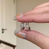 Pendientes de botón de metal con cruz de circonita retorcida, fríos y distantes, para mujer, nicho, personalizados, de moda, modernos, versátiles, joyería para el oído