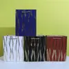 Bolsa de regalo de tarjeta blanca con franja vertical bronceada en stock bolsa para fiesta navideña de ropa al por mayor bolsa de embalaje materia particulada