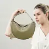 Nova bolsa trançada em formato de meia-lua 2026, um design de nicho para primavera e verão, uma bolsa de ombro casual elegante e minimalista para mulheres