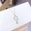 Chapado al vacío conservador de color oro real moda europea y americana ángel colgante redondo carcasa de acero de titanio collar joyería para mujer al por mayor