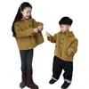 Ropa infantil coreana 2026 otoño e invierno nueva vintage Maillard amarillo jengibre abrigo de lana con capucha de un solo botón para niños y niñas