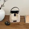 Bolso de paja tipo cubo nuevo estilo vacación de verano en la playa 2026, con un fresco diseño de patchwork en colores contrastantes y una textura tejida simple, un bolso para mujer