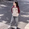 Elegante conjunto de dos piezas para niñas inspirado en el streetwear americano, que incluye una chaqueta con capucha y cremallera de bloques de color y pantalones vaqueros, perfecto para primavera y otoño.