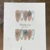 Una uña postiza hecha a mano con un diseño minimalista, transparente como el hielo, rosa-azul nude, ojo de gato zafiro y pedrería colorida dispersa, al estilo de Cang Lan Liu Jin