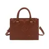 Bolso de mano para mujer con corazón en relieve de estilo nuevo transfronterizo, un bolso de hombro ligero y lujoso de retazos, un bolso cruzado moderno y casual