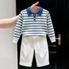 Roupas infantis coreanas 2026 outono e inverno novo estilo suéter de malha de manga comprida com gola polo listrado azul e branco e calça casual reta infantil