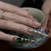 Venta al por mayor de Materiales de Uñas Trendy Estilo Chino Huanhuan, Pedrería de Punta Color Esmeralda Famosa en Internet, Pedrería Redonda de Fondo Plano y Accesorios de Uñas de Perlas