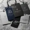 Fábrica de impressão em Dongguan personaliza etiquetas de roupa com LOGOTIPO, papel especial com estampagem a ouro, em conformidade com os regulamentos PPWR
