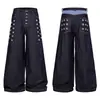 Pantalones de mezclilla anchos color azul oscuro sin lavar con múltiples filas de remaches metálicos en el lateral, cierre de botón, corte holgado, efecto adelgazante, pantalones largos para hombre