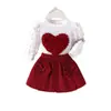 Conjunto de Roupa Infantil Novo Mais Vendido na Fronteira, Estilo Europeu e Americano, Conjunto de Duas Peças com Top de Manga Bufante em Forma de Coração com Laço e Saia Curta para Meninas
