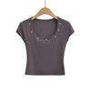 Camiseta de manga corta con cuello redondo grande y botones de uñas, estilo europeo y americano, con remaches decorativos de verano 2024 para mujer