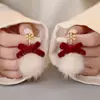 Brincos de pelúcia vermelha Brincos de bola de cabelo de ano novo 2024 Novos brincos de explosão para mulheres Brincos de laço de sentido de alta qualidade