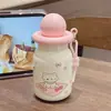 Botella de agua estilo estudiante, minimalista, linda y moderna con un alto atractivo estético, que presenta un diseño portátil, estilo popular de celebridad de internet, motivos de dibujos animados y una pajita de acero inoxidable y construcción aislada.