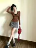 Conjunto de roupa modeladora estilo coreano: cardigã marrom justo combinado com minissaia cinza em linha A, conjunto de duas peças para baixinhas parecerem mais altas
