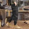 Nova coleção Primavera 2026: Calças cargo de alta qualidade, modernas e de corte slim para homens, com modelagem solta, múltiplos bolsos e um design casual preto, adequadas para primavera e outono.
