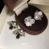 Aretes de flor de resina perlada incrustados con diamantes estilo francés, que exudan un ambiente lujoso y elegante, con un diseño moderno y único