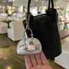 Bolsa de cuero remachada a mano con colgante de cuero plateado 2025 nuevo bolso de saturno plateado de alta gama colgante de polvo para bolso llavero