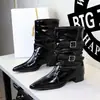 Botas de pierna ancha estilo retro con hebillas de cuero, con un diseño Chelsea de punta inspirado en el británico, charol, tacones gruesos y un tobillo plisado y fruncido.