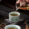 Un juego de cinco tazas de té exquisitas de los Cinco Hornos Famosos, que incluye tazas de té maestras de cerámica remachadas, tazas de degustación y cuencos de té, presentado en una caja de regalo como un juego para la ceremonia del té y un recuerdo perfecto