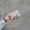 Nova Carteira Feminina Tendência Primavera/Verão 2025, Curta, de Mão, com Pingente em Formato de Coração, Padrão Lichia, Moda Casual, Multifuncional