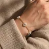 Pulsera Minimalista de Acero de Titanio Transfronteriza para Mujer con Pequeñas Flores de Margarita, Accesorio de Mano de Moda Versátil Estilo Ins, Joyería para Mujer con un Toque de Alta Gama