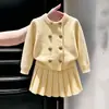 Colección de otoño 2026 para niñas estilo coreano: un conjunto de punto amarillo cremoso que incluye un cárdigan suéter y una falda plisada, diseñado en un estilo chic, como de bebé