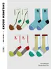 Calcetines para niños ZYZ al por mayor otoño nueva letra calcetines para correr para niños calcetines de tubo deportivos de ocio de goma alta para niños