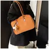 A bolsa Boston popular deste ano para mulheres é o novo modelo de 2026, uma bolsa de ombro vintage casual e versátil adequada para o trabalho e o trajeto, também conhecida como bolsa travesseiro.