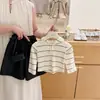 Xian Ning QiAs calças de couro têm um ótimo estilo! Este conjunto de outono para bebês inclui um top listrado com capuz e um par de calças de couro.