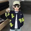 Cárdigan de Punto Bordado de Dinosaurio para Niños Primavera y Otoño 2026 Nuevo Estilo de Otoño Chaqueta Suéter de Dibujos Animados para Niño Fresco de Moda