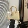 Bolso bandolera elegante y chic de un solo hombro, con un diseño minimalista y una forma pequeña y cuadrada.. Esta es la colección de verano 2026 de bolsos de mujer de moda