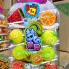 Paletas y Caramelos Duros en Varias Formas de Frutas para que los Niños Compartan Dulces y Den a sus Amigos Regalos Navideños. Puestos en la Puerta de la Escuela