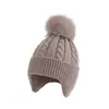 Gorro de punto grueso para adultos de venta caliente transfronterizo, color liso con pompón, cálido y a prueba de viento, gorro de punto para cubrir las orejas al aire libre