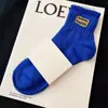 Calcetines antibacterianos para hombre y mujer calcetines altos negros y blancos cuatro estaciones color liso calcetines deportivos absorbentes de sudor desodorantes calcetines de moda con alfabeto