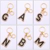 Llavero con colgante de aleación creativa con letras en inglés y gota de aceite de aleación con diamantes.