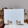 Pendientes elegantes y exquisitos con microincrustaciones de circonitas y perlas de estilo coreano Dongdaemun, con lazo creativo, agujas de plata S925 pequeñas y frescas.
