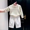 Nueva colección de otoño/invierno 2026 para niños estilo coreano: Suéter de punto color hueso con rayas verdes, combinado con pantalones blancos de pierna ancha - un conjunto de dos piezas