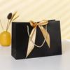 Bolsa de papel para ropa, bolsa de regalo con lazo, bolsa de compras, bolsa de embalaje de color sólido, logotipo imprimible, venta al por mayor