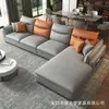 Sofá minimalista de dos tonos para cuatro plazas con respaldos y reposapiés segmentados en gris oscuro y naranja, adecuado para salas de estar pequeñas.