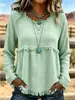 Blusa longa de manga comprida, estilo boho europeu e americano, com franjas, textura e amassada, gola redonda, corte solto e ombros caídos.