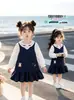Vestido con Cuello de Muñeca Estilo Universitario para Niñas 2026 Otoño Nuevo Camisa de Manga Larga con Cuello de Muñeca para Niña Pequeña Vestido de Tirantes