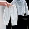 Ropa Infantil Estilo Coreano 2026 Otoño/Invierno Nueva Llegada Suéter de Punto con Cuello Polo a Cuadros Azul Claro Pantalones Blancos de Pierna Ancha para Niños Modernos