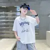 Verão 2026 Novo Estilo Camiseta Infantil Tendência Americana Cool Estampa de Letras Manga Curta Masculina Casual Gola Redonda Confortável para Crianças de Tamanho Médio e Grande